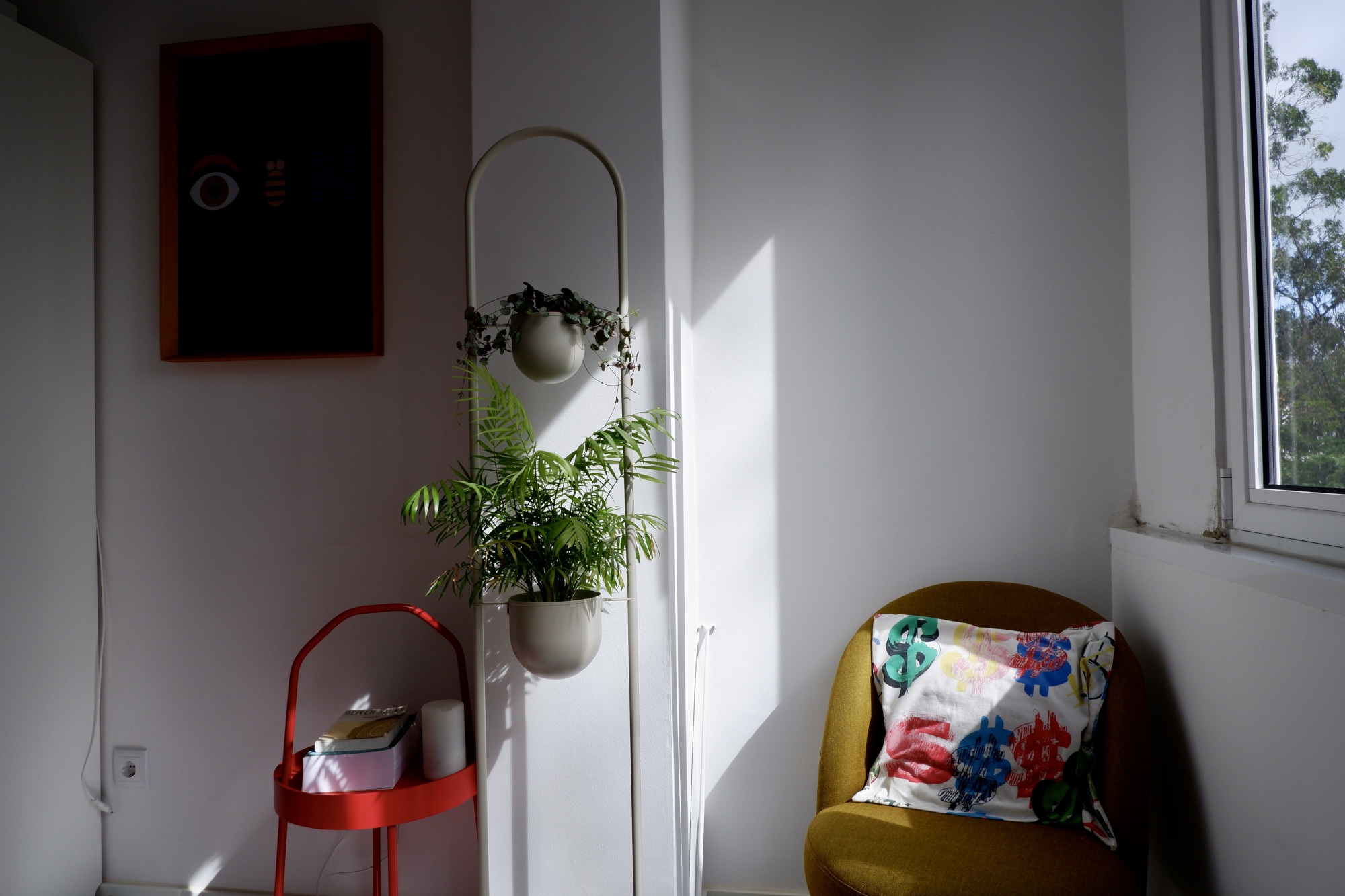 Room corner with plants, tiny sofa table and a chair